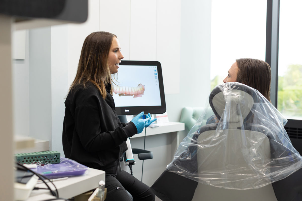 Dentist explaining dental scan to patient at Village Dental in Village, CO