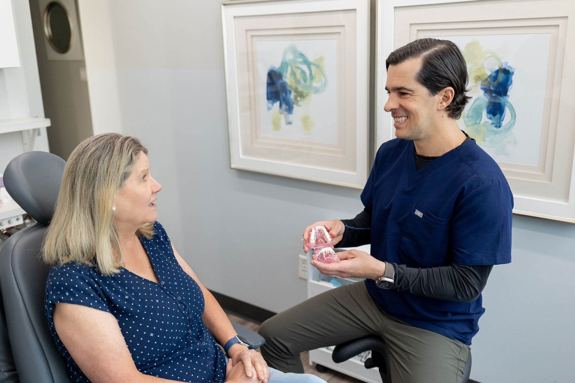 Dentist explaining dental models to patient at Village Dental in Village, CO