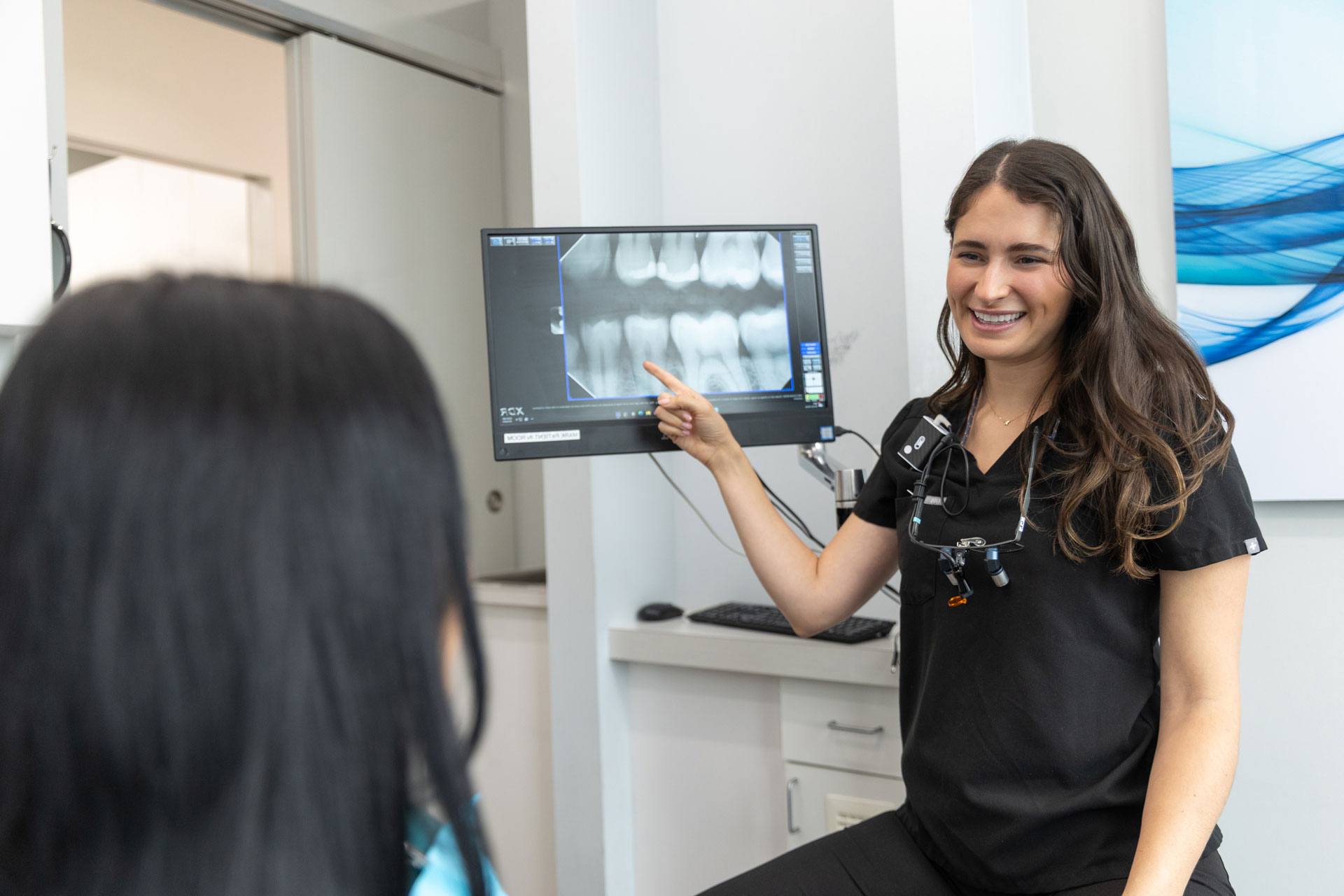 Dentist explaining dental X-ray at Village Dental in Village, CO