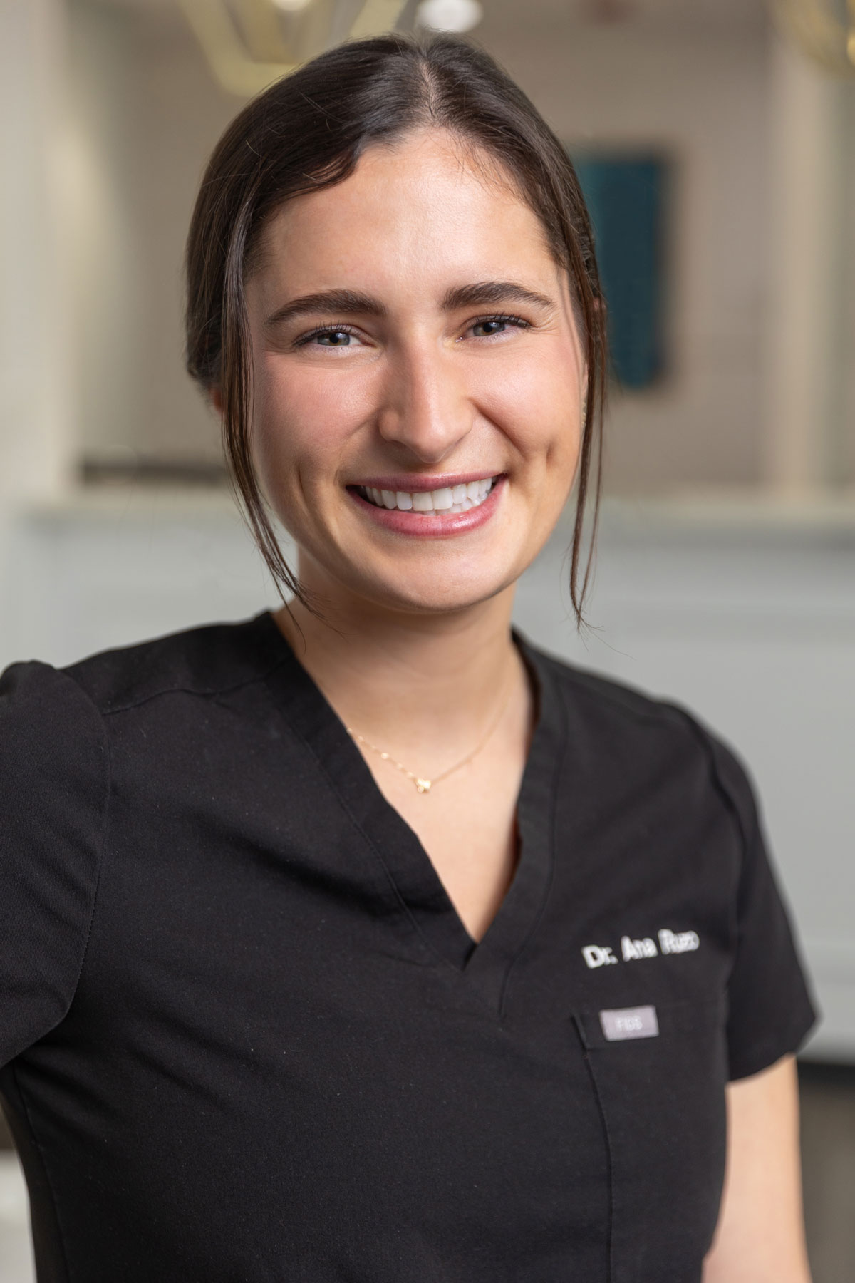 Smiling dentist wearing black scrubs at Village Dental in Village, CO